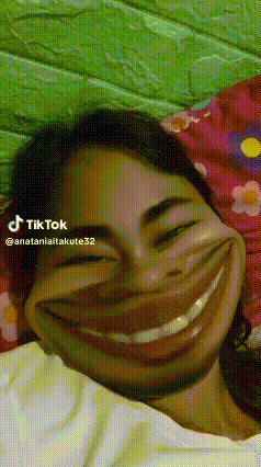 a woman is laying on a bed with a big smile on her face