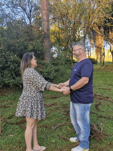 a man and a woman hold hands in a park