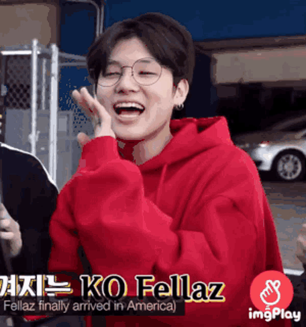 a young man wearing glasses and a red hoodie is laughing and says ko fellaz