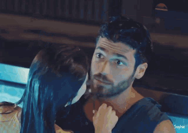 a man and a woman are kissing in a pool with the name sophie written on the bottom
