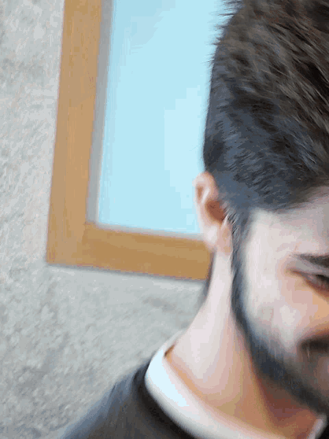 a man with a beard and a black shirt is looking at the camera
