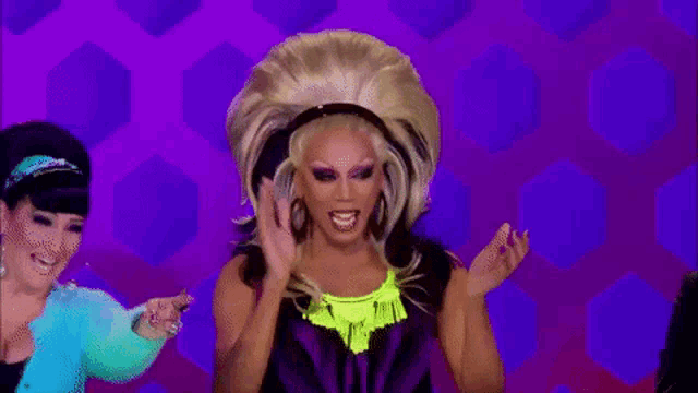 a drag queen with a huge wig and a neon yellow top