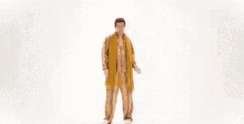 a man in a leopard print shirt and glasses is dancing with his arms outstretched .