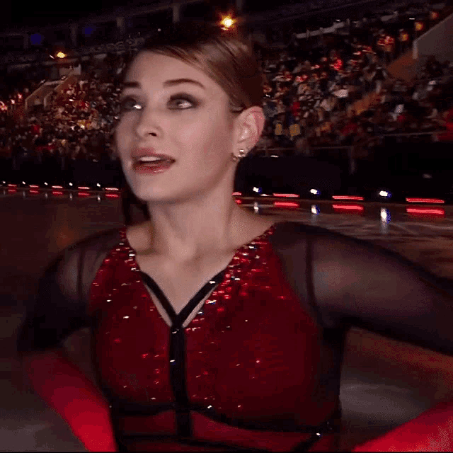 a woman in a red dress is standing on a rink
