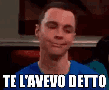 a man in a blue shirt is smiling with his eyes closed and the words `` te l' avevo detto '' below him .