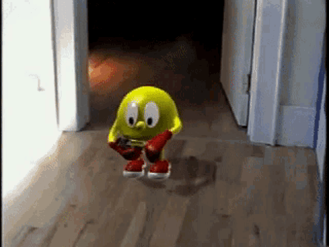 pac man is walking down a hallway holding a remote control