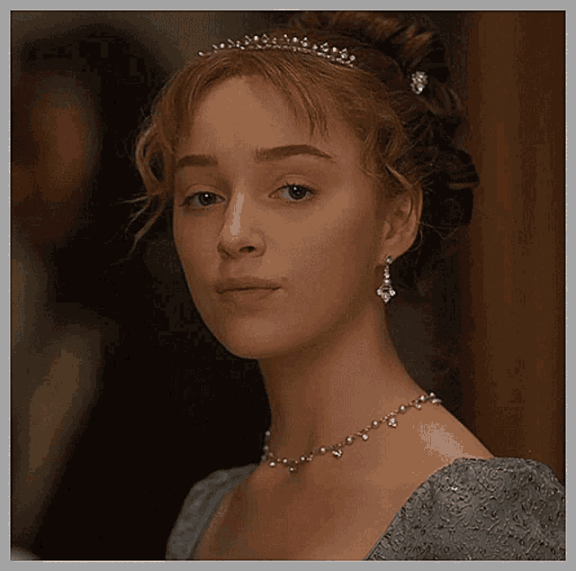 a close up of a woman wearing a necklace and a tiara