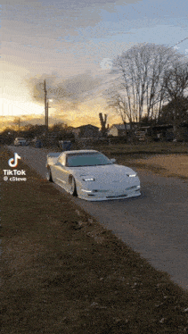 a white corvette is parked on the side of the road