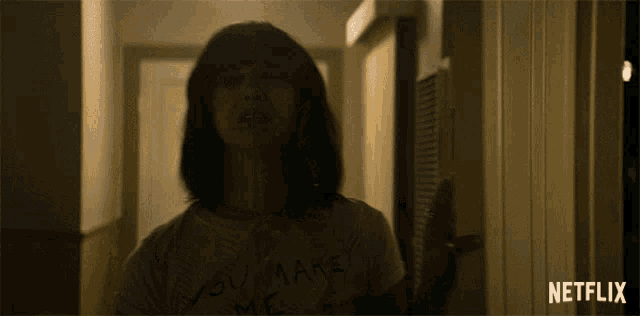 a woman wearing a shirt that says ' you make me ' on it