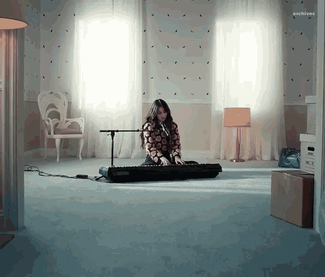 a woman is playing a yamaha keyboard in a living room