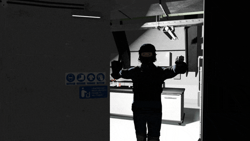 a man is standing in a dark room with a sign on the wall that says " do not enter if you are pregnant "