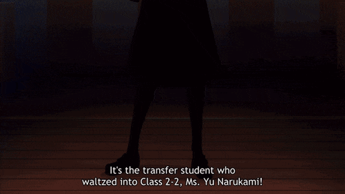 a woman is standing in a dark room wearing a plaid skirt