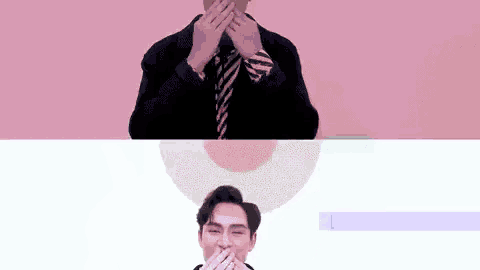 a man in a suit and tie covering his face with his hands