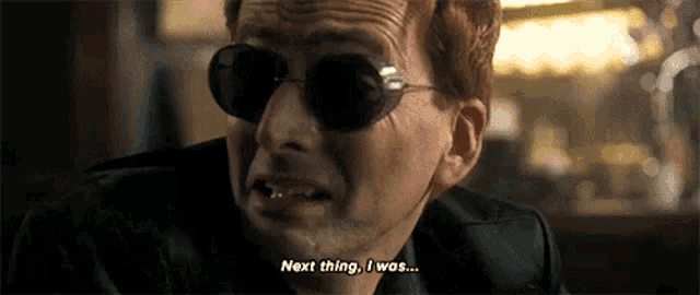 a man wearing sunglasses and a leather jacket is talking to another man .