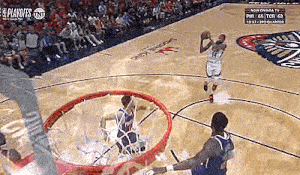 a basketball player is getting ready to shoot the ball while another player watches .