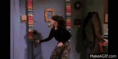 a woman is standing in a doorway holding a door handle .