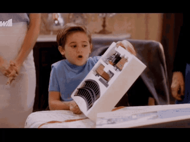 a little boy is holding a box with a w1 logo in the corner