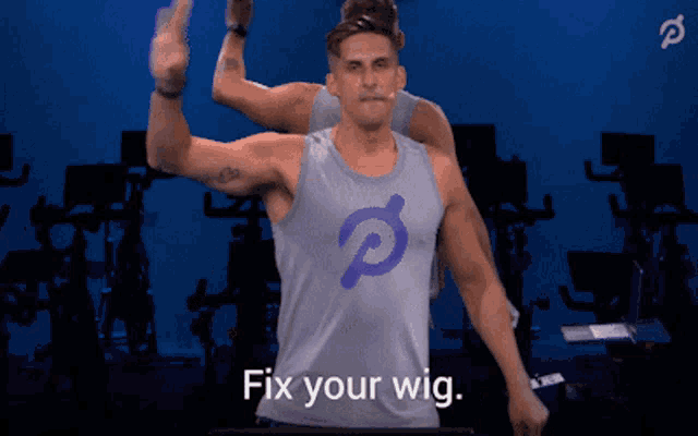 a man wearing a peloton tank top giving the middle finger