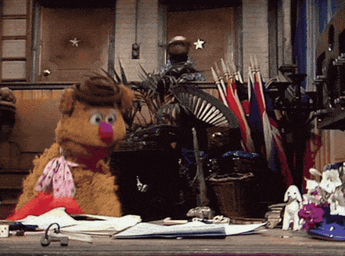 a stuffed animal wearing a cowboy hat is sitting on a desk