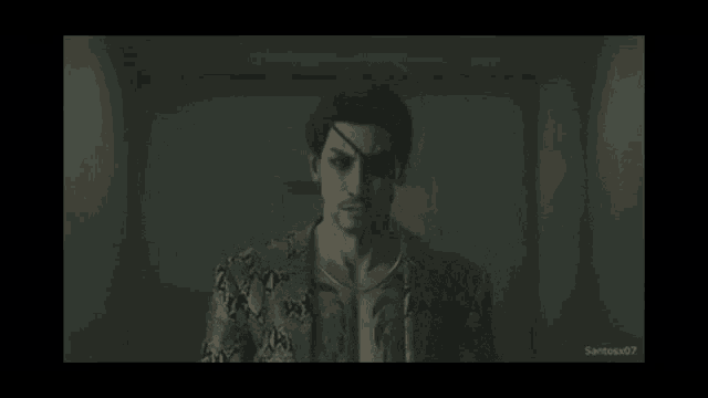 a man in a snakeskin jacket is standing in a dark room with a tattoo on his eye .