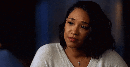 the woman is wearing a white sweater and a necklace .