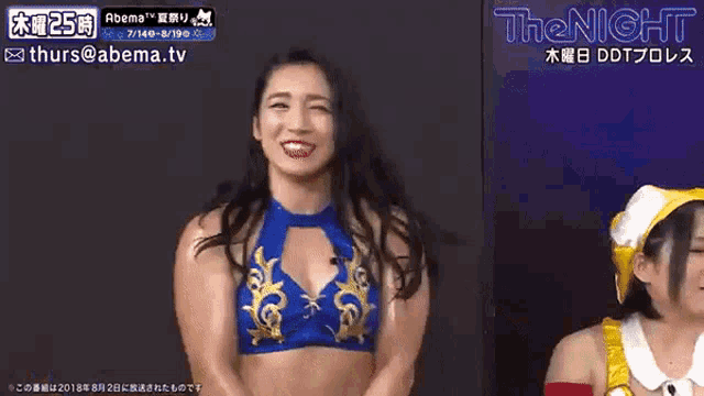 two women are dancing in front of a sign that says ' the night ' on it