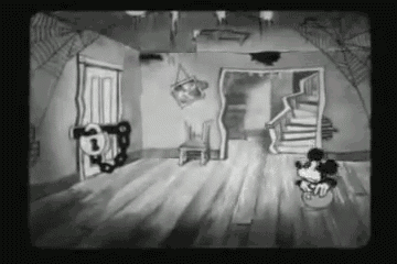 a black and white cartoon of mickey mouse standing in a room with a staircase .