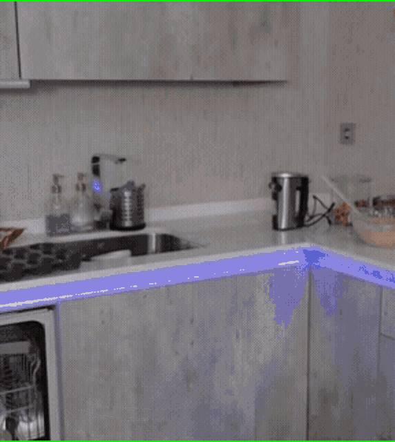 a blurry picture of a woman in a kitchen with a blender in the background