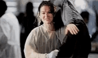 a man is carrying a woman on his back in a hospital room .