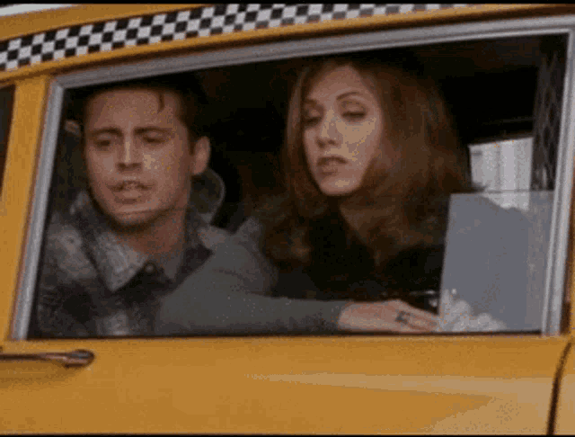 a man and a woman are sitting in a yellow taxi cab
