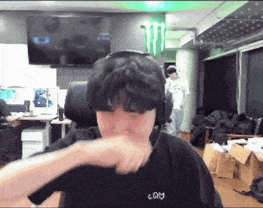 a man wearing headphones and a black shirt that says com