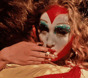 a close up of a woman 's face with a red heart on it