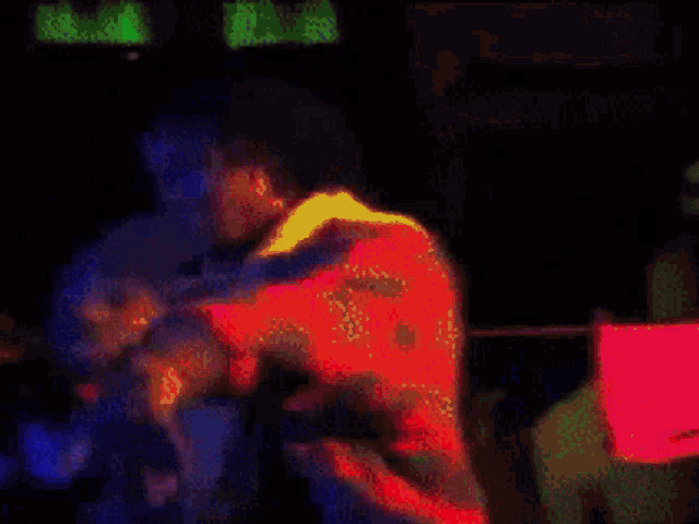 a blurry picture of a person in a dark room with a green light behind them