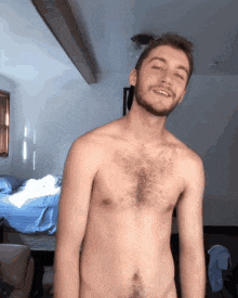 a shirtless man with a beard is standing in a room