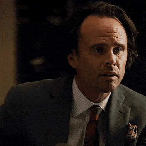 a man in a suit and tie is looking at something