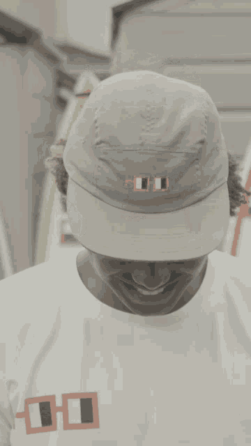 a young man wearing a hat and a white shirt with the letters thd on the front