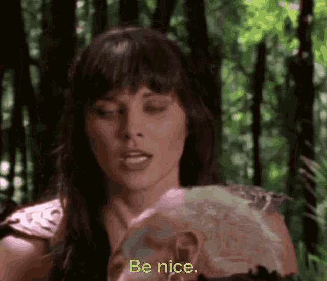a woman is talking to a man in the woods and says be nice