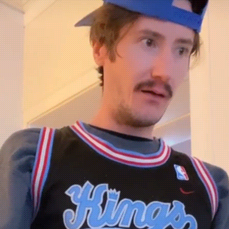a man wearing a kings jersey with a hat on his head