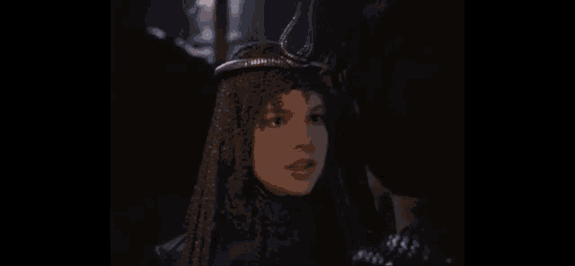 a woman wearing a veil and a crown is looking at a man .
