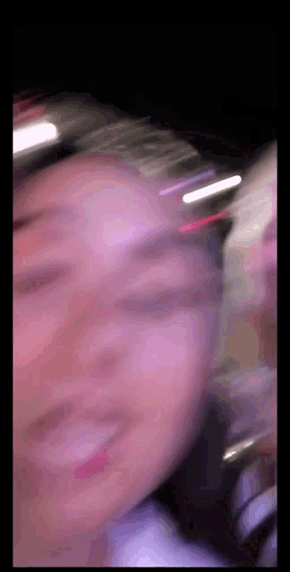 a blurry photo of a woman 's face with a purple background