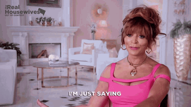 a woman says i 'm just saying in front of a fireplace