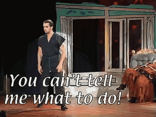 a man standing on a stage with the words you can 't tell me what to do behind him