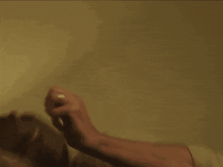 a woman is holding a gun in her right hand and pointing it at the camera .