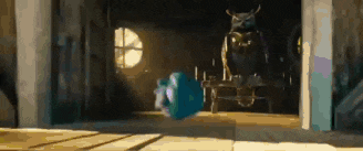 a cartoon character is standing in a room with a statue of an owl behind him .