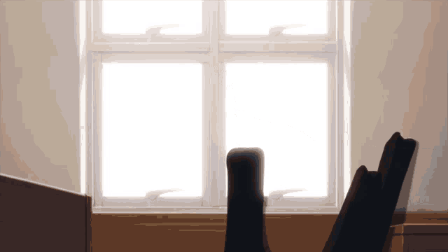 a chair sits in front of a window with the sun shining through