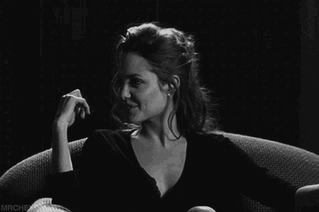 a black and white photo of a woman smiling