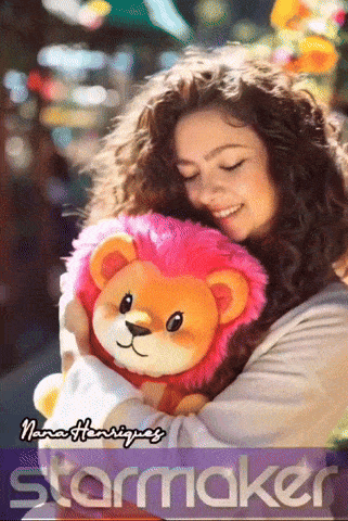 a woman is holding a stuffed lion with the name nana henriquez on the bottom