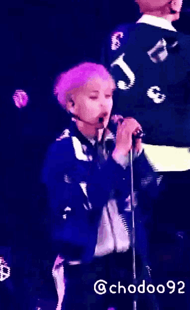 a person with purple hair singing into a microphone with the number 3 on their back