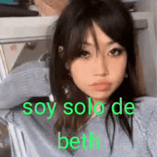 a girl is sitting in a chair with the words soy solo de beth on her face