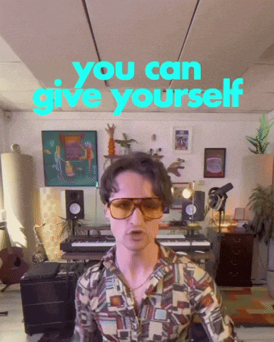 a man wearing sunglasses is standing in front of a sign that says you can give yourself